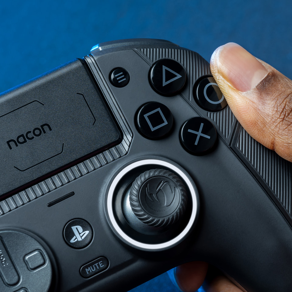 Primer plano de un mando Nacon PS5 negro con la mano de una persona sobre él.