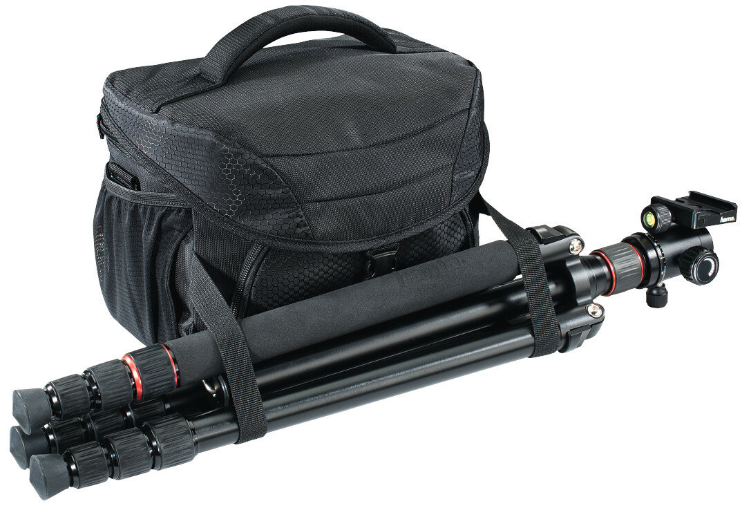 Czarna torba na aparat z dołączonym czarnym statywem, oba na białej powierzchni, z białym tłem.