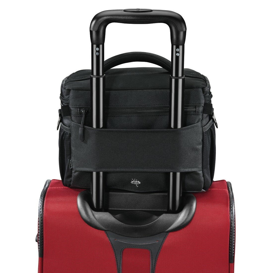 Czarna torba na aparat na czerwonej walizce z wysuniętym uchwytem.