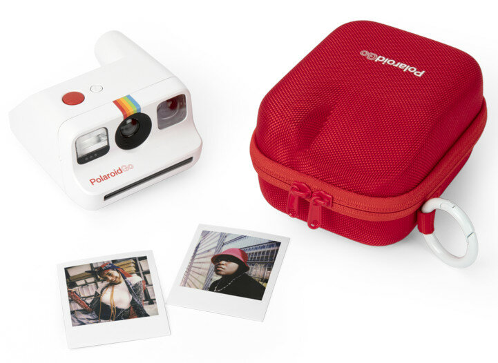 Aparat Polaroid Go z etui i zdjęciami. Biały aparat i czerwone etui.