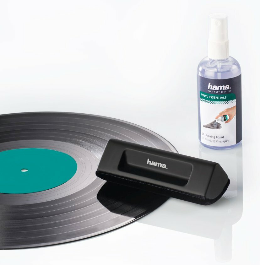 Płyta winylowa ze szczoteczką i sprayem czyszczącym. Białe tło.