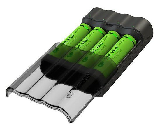 Ładowarka do baterii z czterema zielonymi akumulatorami, przezroczysta osłona. Z bliska.