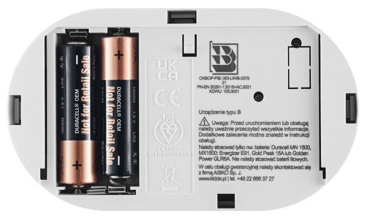 Komora baterii z dwiema bateriami Duracell OEM. Białe tło z tekstem i symbolami.