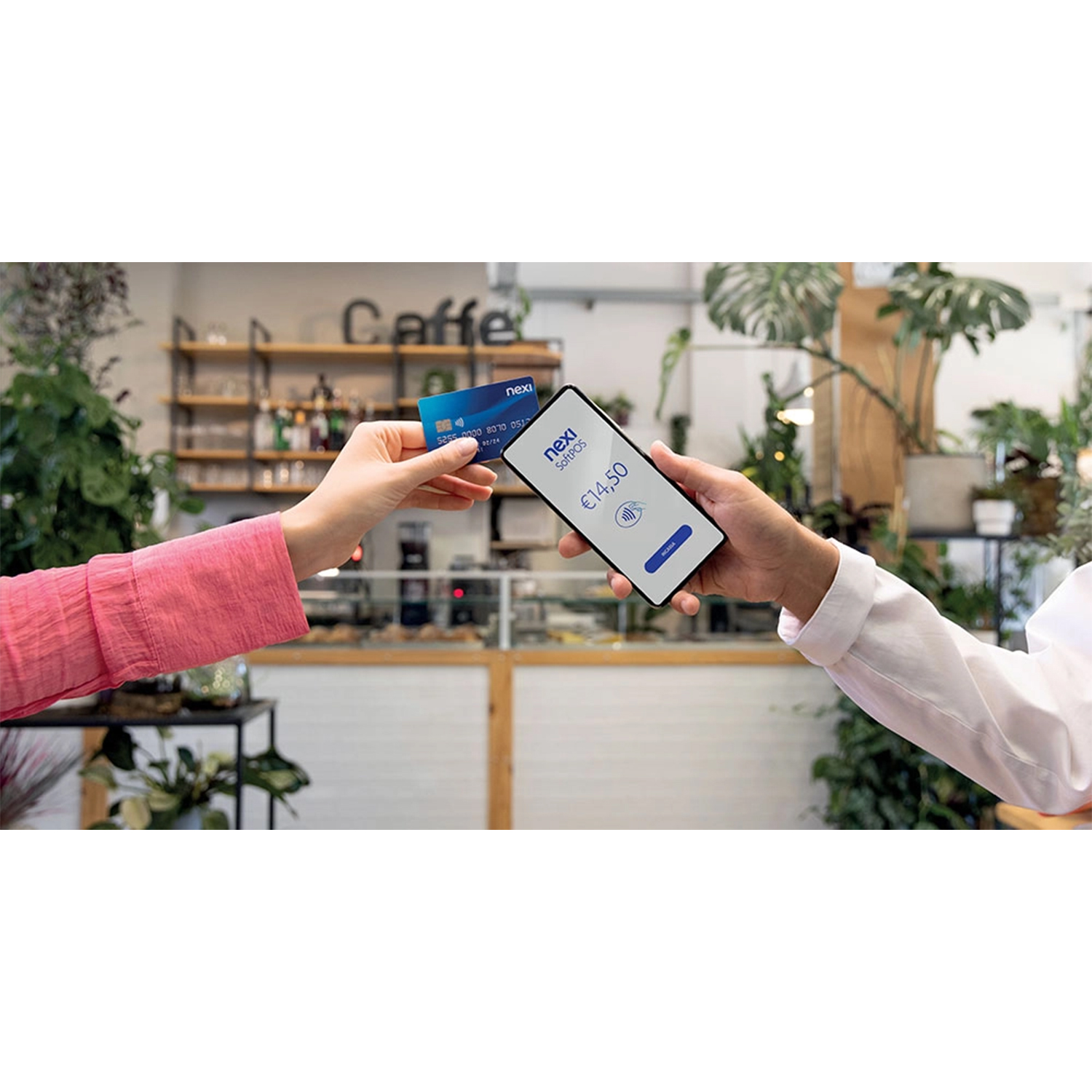 Mani che scambiano carta di credito e telefono per il pagamento in un bar.