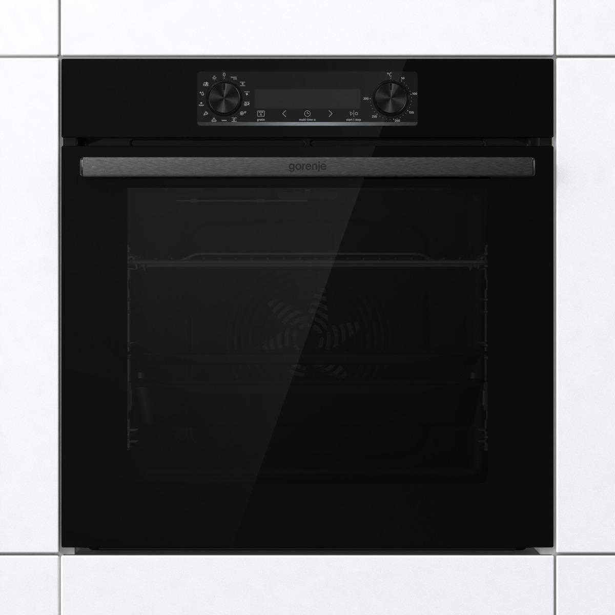 Ein schwarzer Gorenje-Backofen, eingebaut in eine weiß geflieste Wand. Es hat eine Glastür.