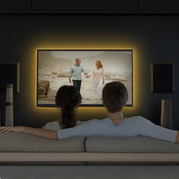 Para ogląda telewizję, z żółtą obwódką świetlną. Ekran pokazuje parę.