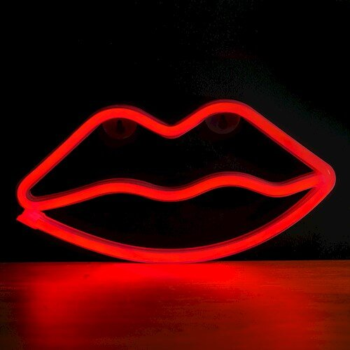 Czerwony neonowy znak ust na ciemnym tle z odbiciem na powierzchni.