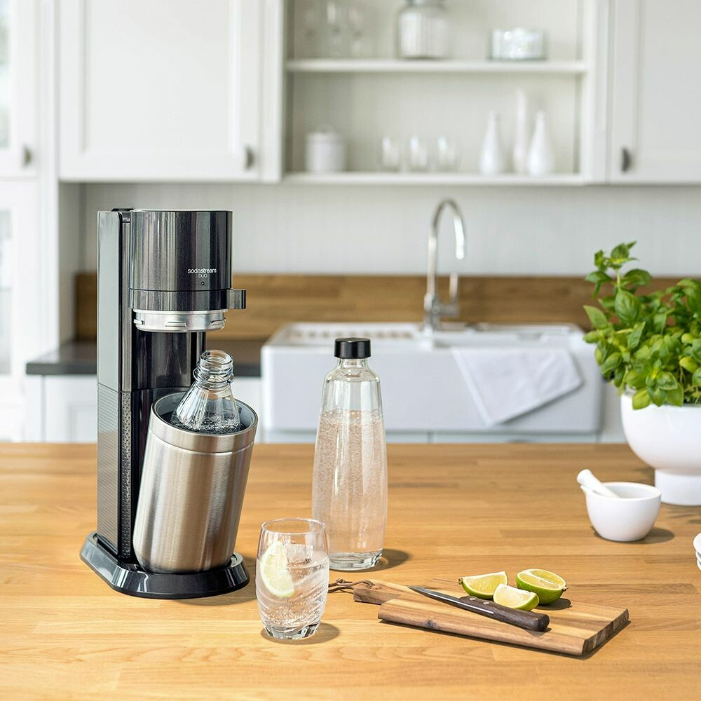 SodaStream gép fa pulton, pohárral és citrommal.