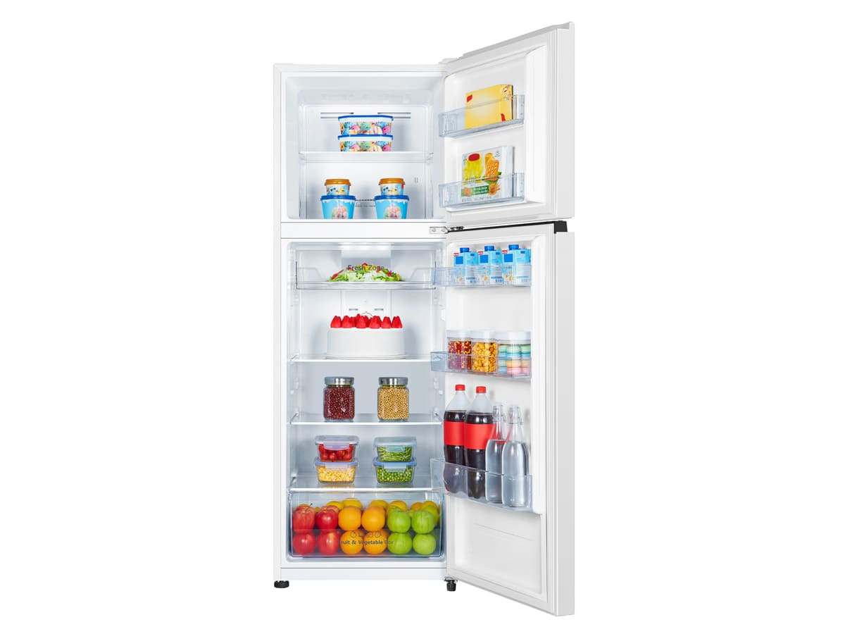 Refrigerador blanco abierto lleno de alimentos, incluyendo frutas, bebidas y frascos.