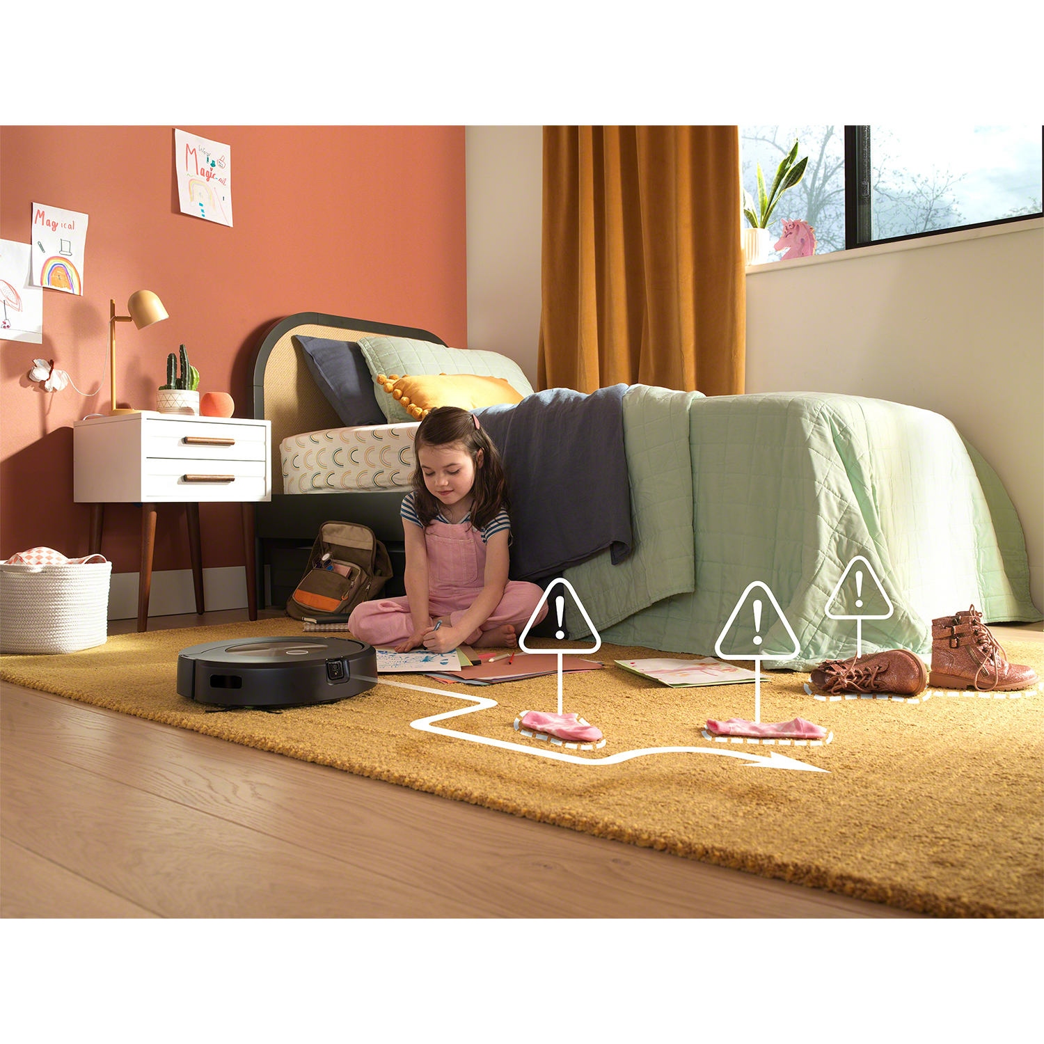 Bambina in camera da letto, che disegna, aspirapolvere robot che pulisce. Segnali di pericolo intorno agli ostacoli.