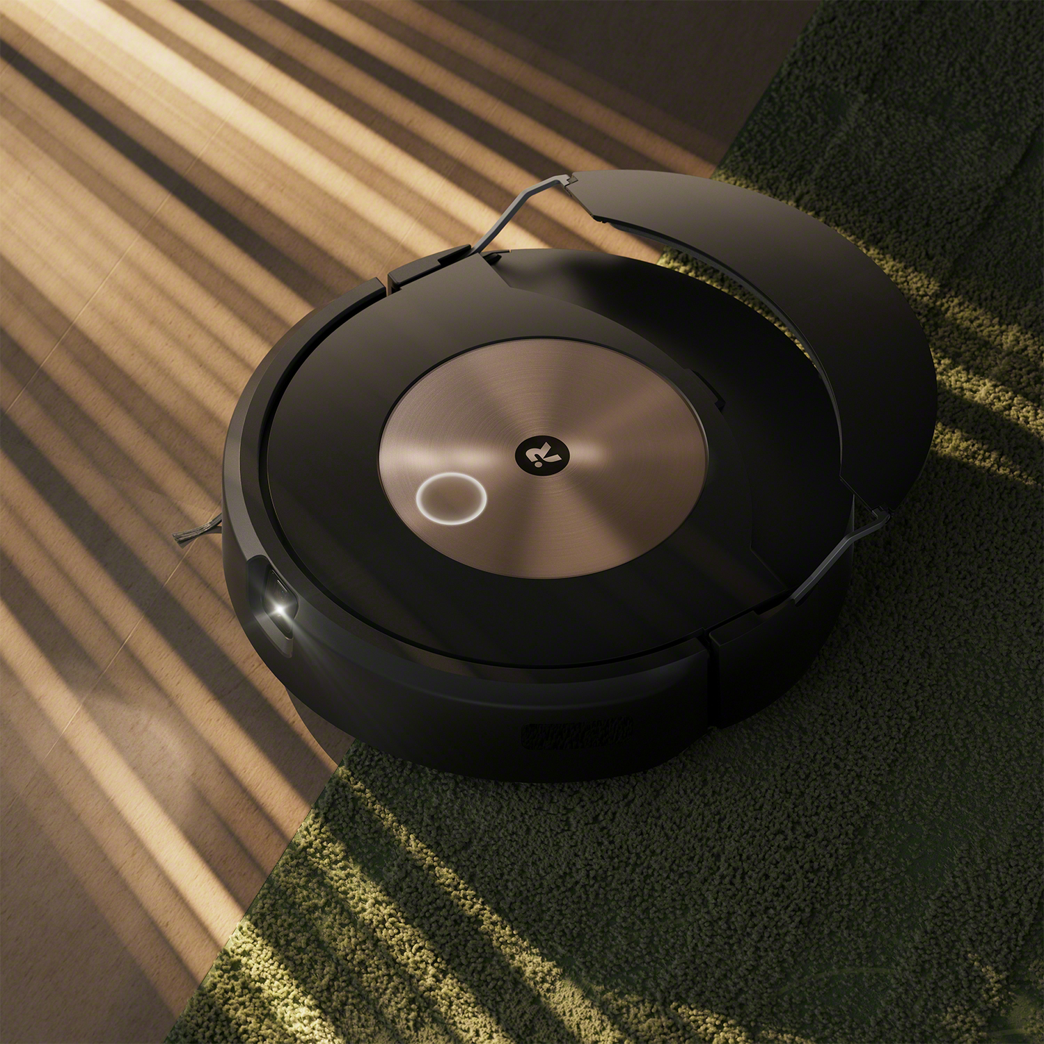 Aspirapolvere robot nero su un tappeto verde.