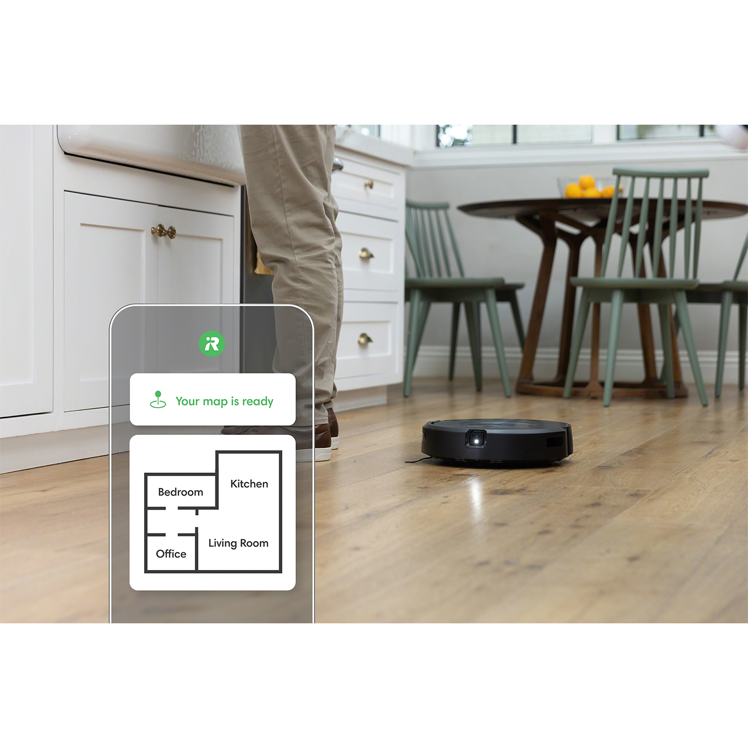 Aspirapolvere robot su un pavimento in legno. Una mappa è su un tablet vicino, che mostra la disposizione della stanza.