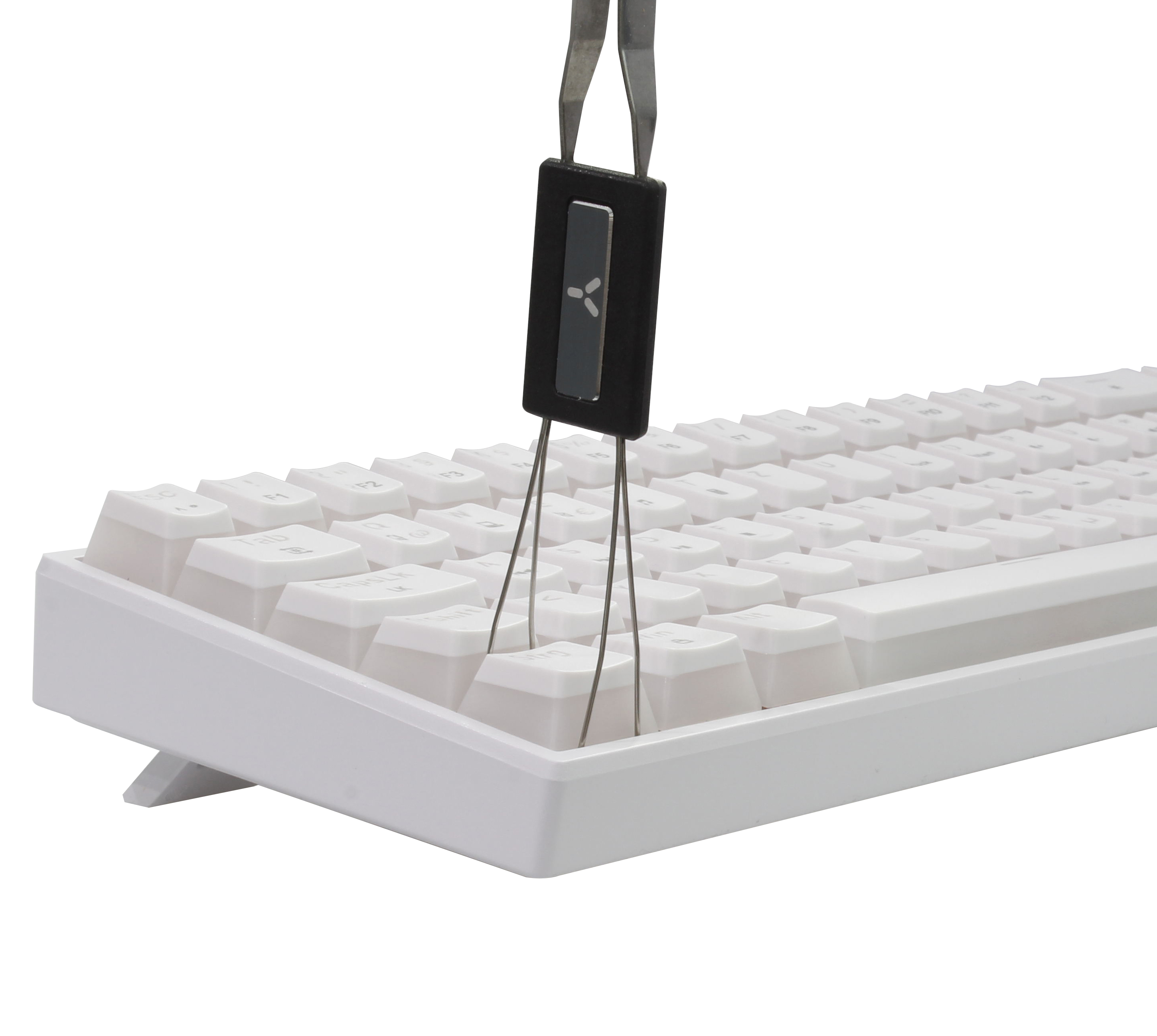 Pinzette hält eine schwarze Tastenkappe über einer weißen Tastatur mit weißen Tastenkappen.