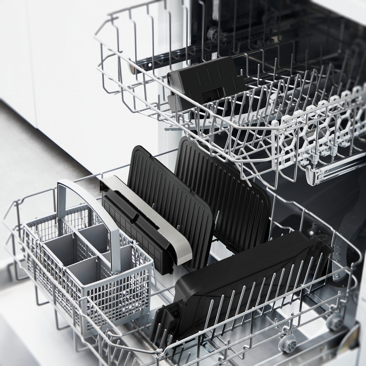 Vaatwasserinterieur met rekken met zwarte grillplaten en een bestekmand.