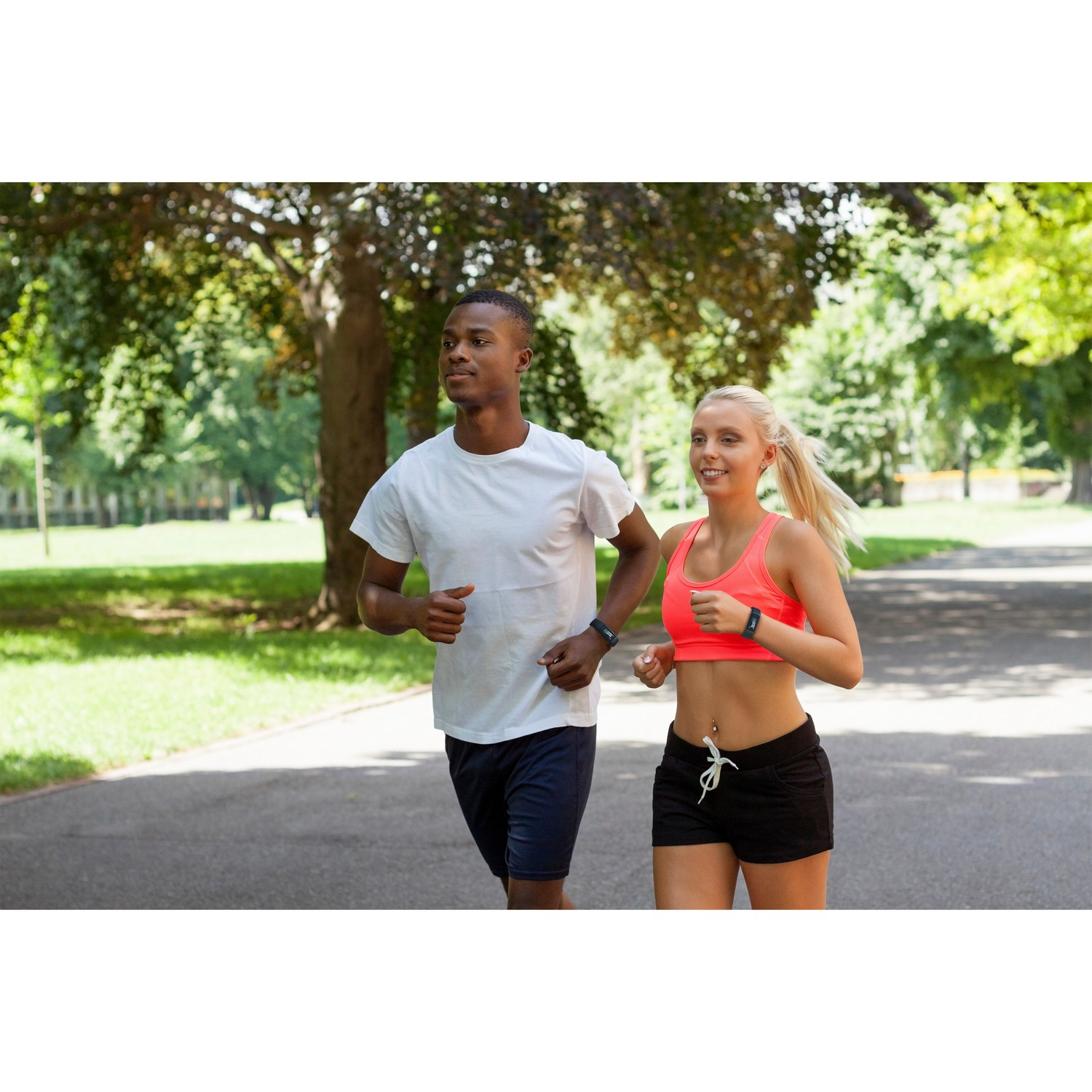 Deux personnes courant sur un sentier dans un parc, portant des trackers de fitness.