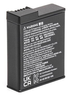 Czarna bateria z ostrzeżeniami, tekst w wielu językach. Na dole UKCA i KC.