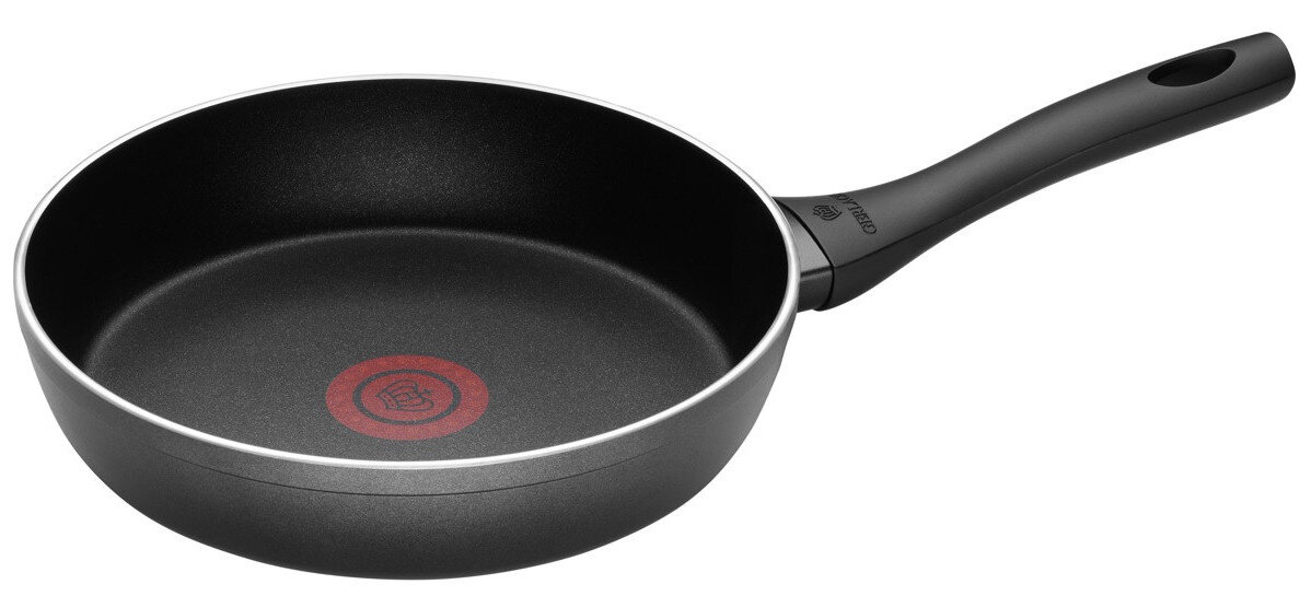 Czarna patelnia z czarnym uchwytem i czerwonym okręgiem pośrodku. Widok z boku.