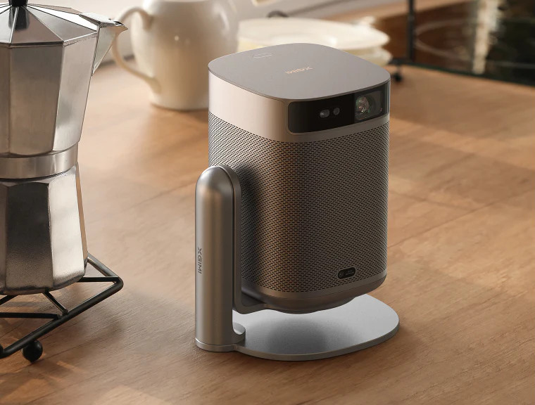 Een projector op een standaard naast een koffiezetapparaat.