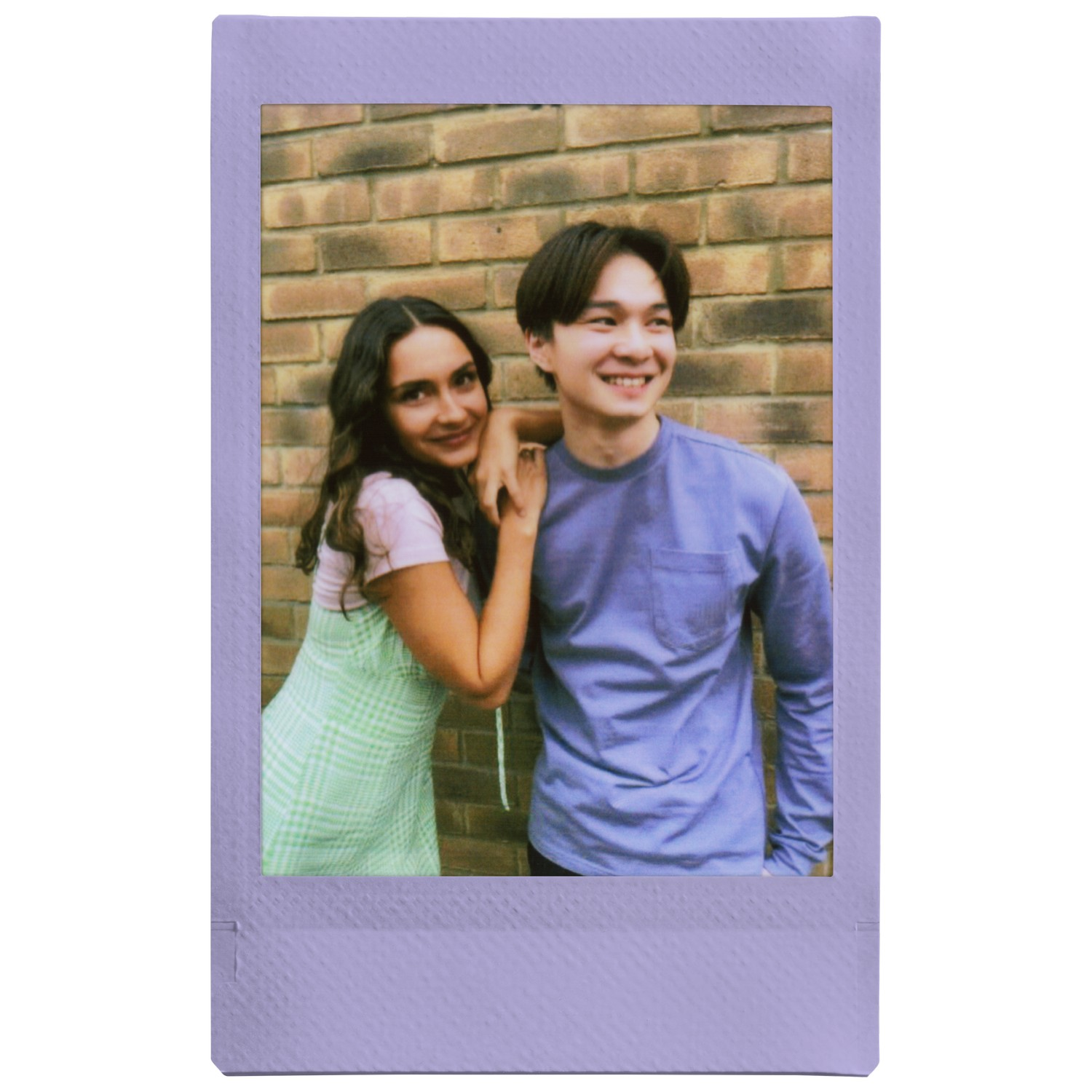 Photo style Polaroid d'une femme et d'un homme souriants, adossés à un mur de briques.