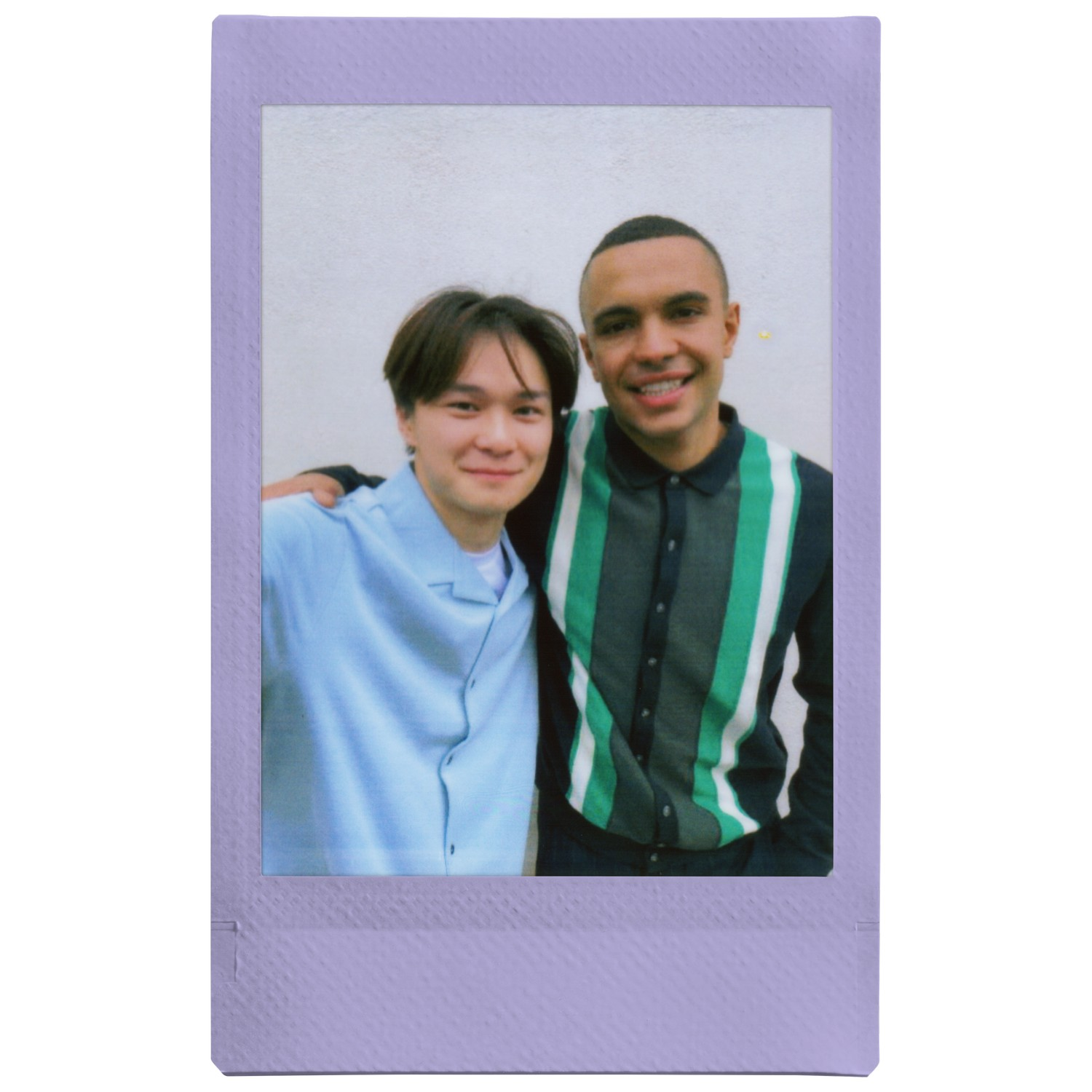 Deux jeunes hommes souriants, posant pour une photo dans un cadre polaroid.