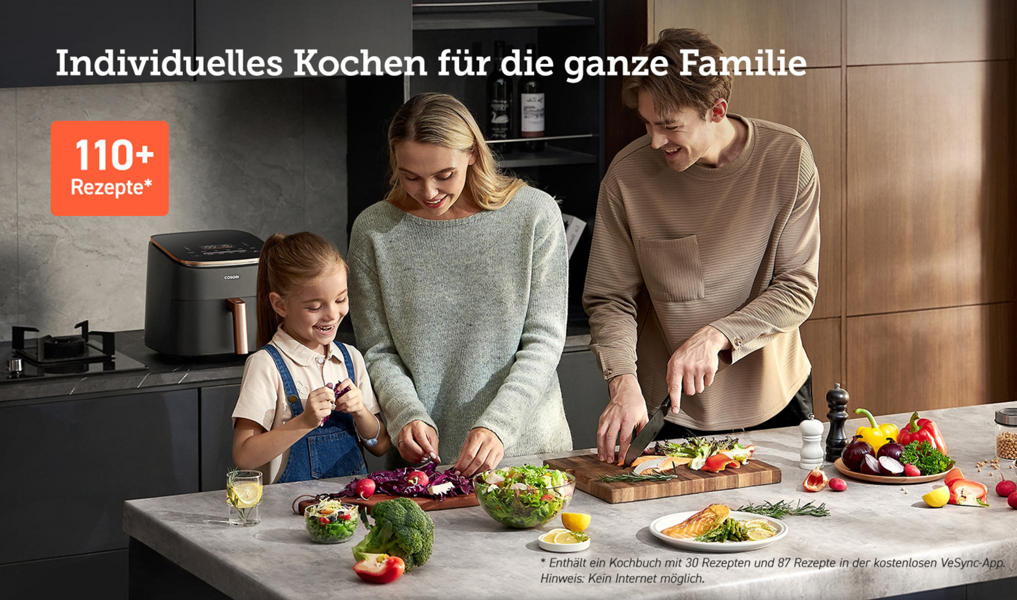 Familie bereitet Essen an einer Küchentheke zu, im Hintergrund eine Heißluftfritteuse.