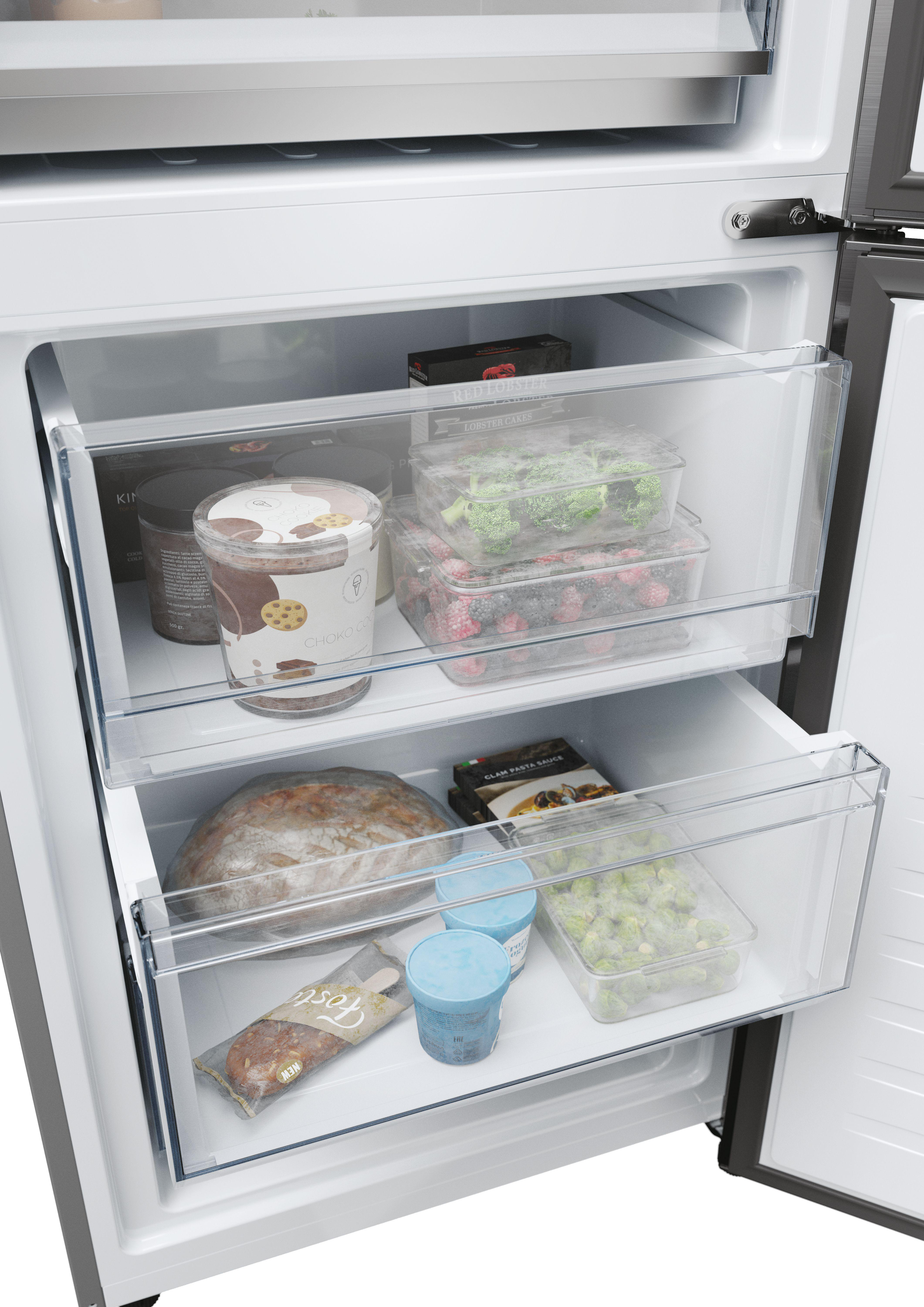Offener Kühlschrank, Innenansicht. Enthält Schubladen mit Lebensmitteln. Oberes Regal und Gefrierfach sichtbar.