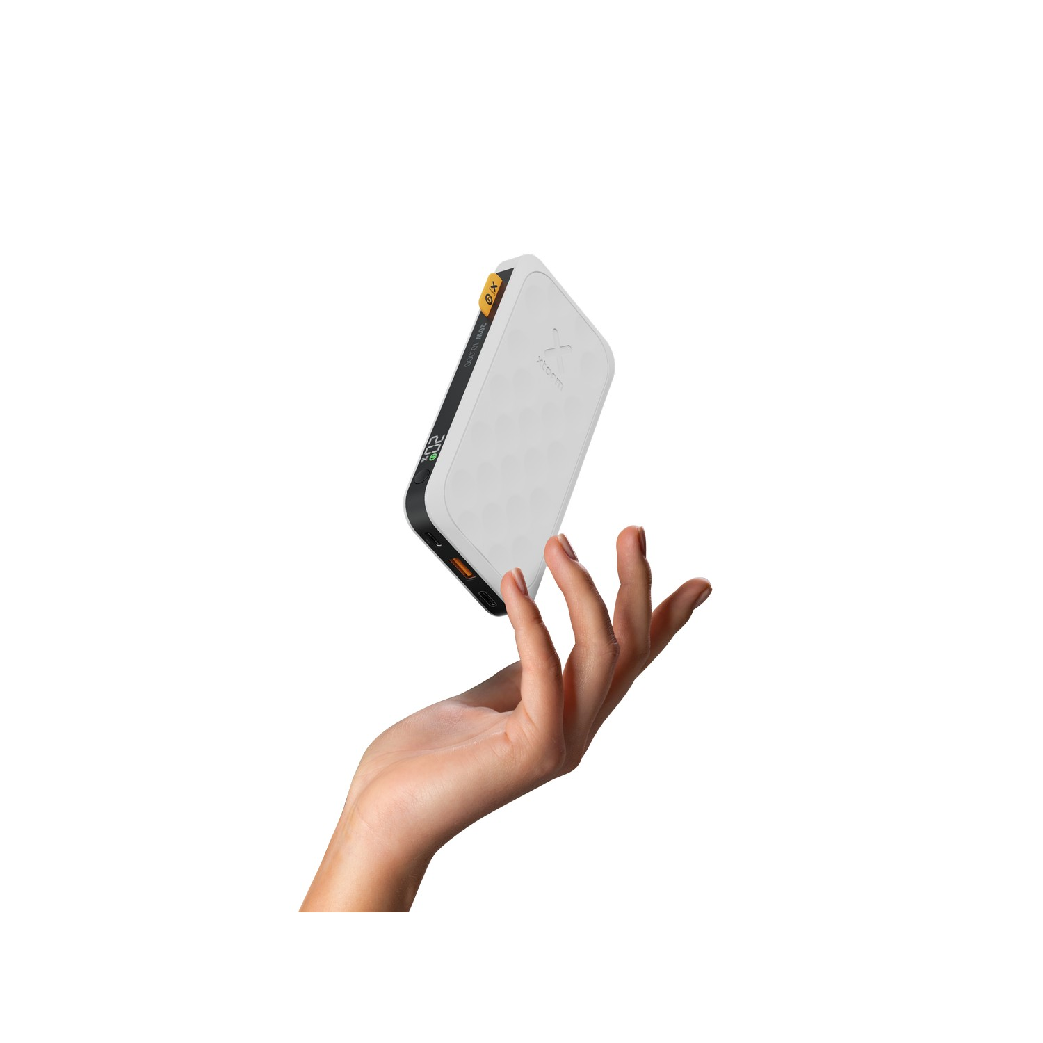 Main tenant une batterie externe blanche avec des accents jaunes, sur fond blanc.