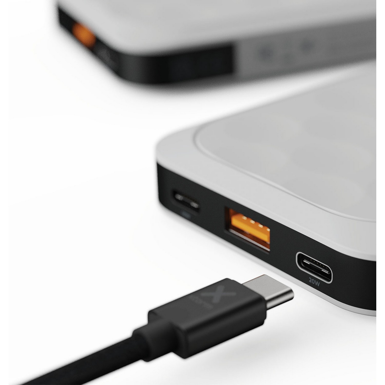 Deux batteries externes avec un câble de chargement. L'une a un port jaune. Fond blanc.