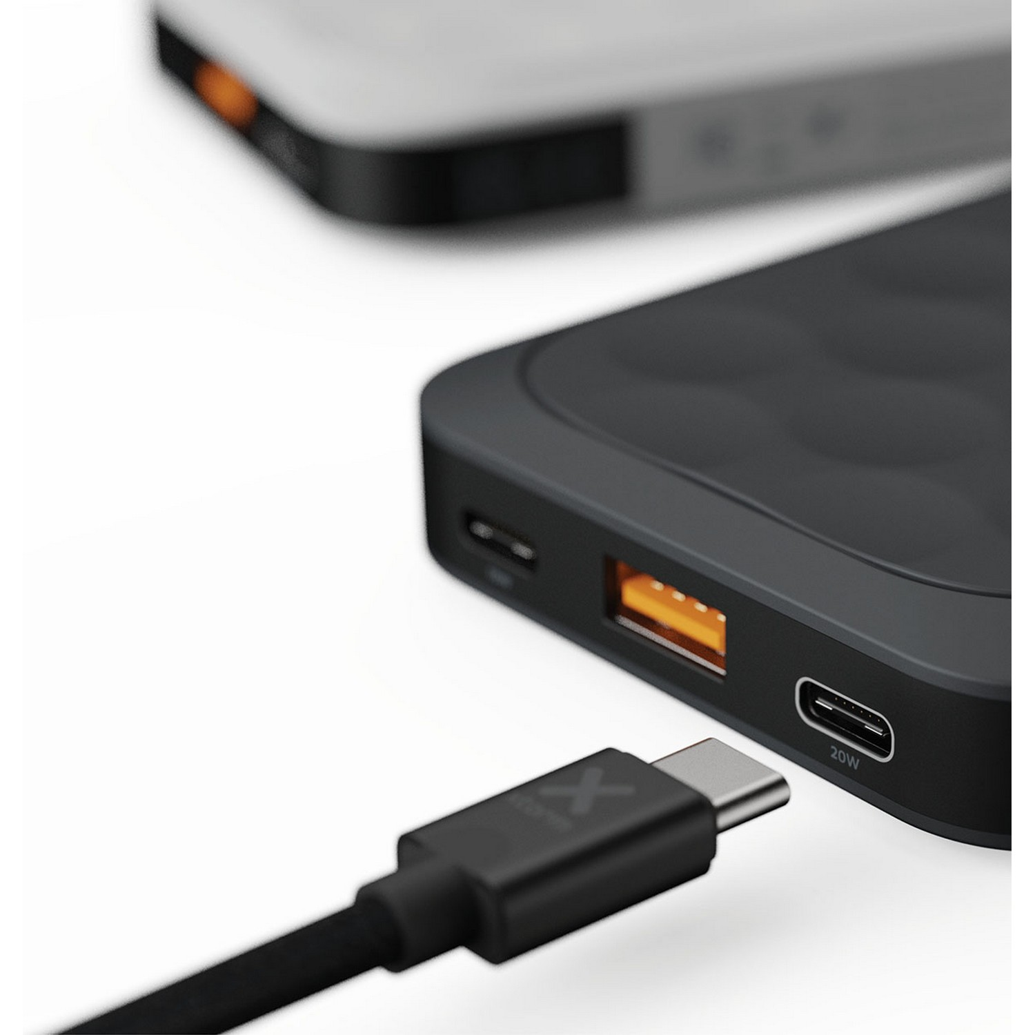 Batterie externe avec un câble USB-C branché, chargeant un autre appareil.