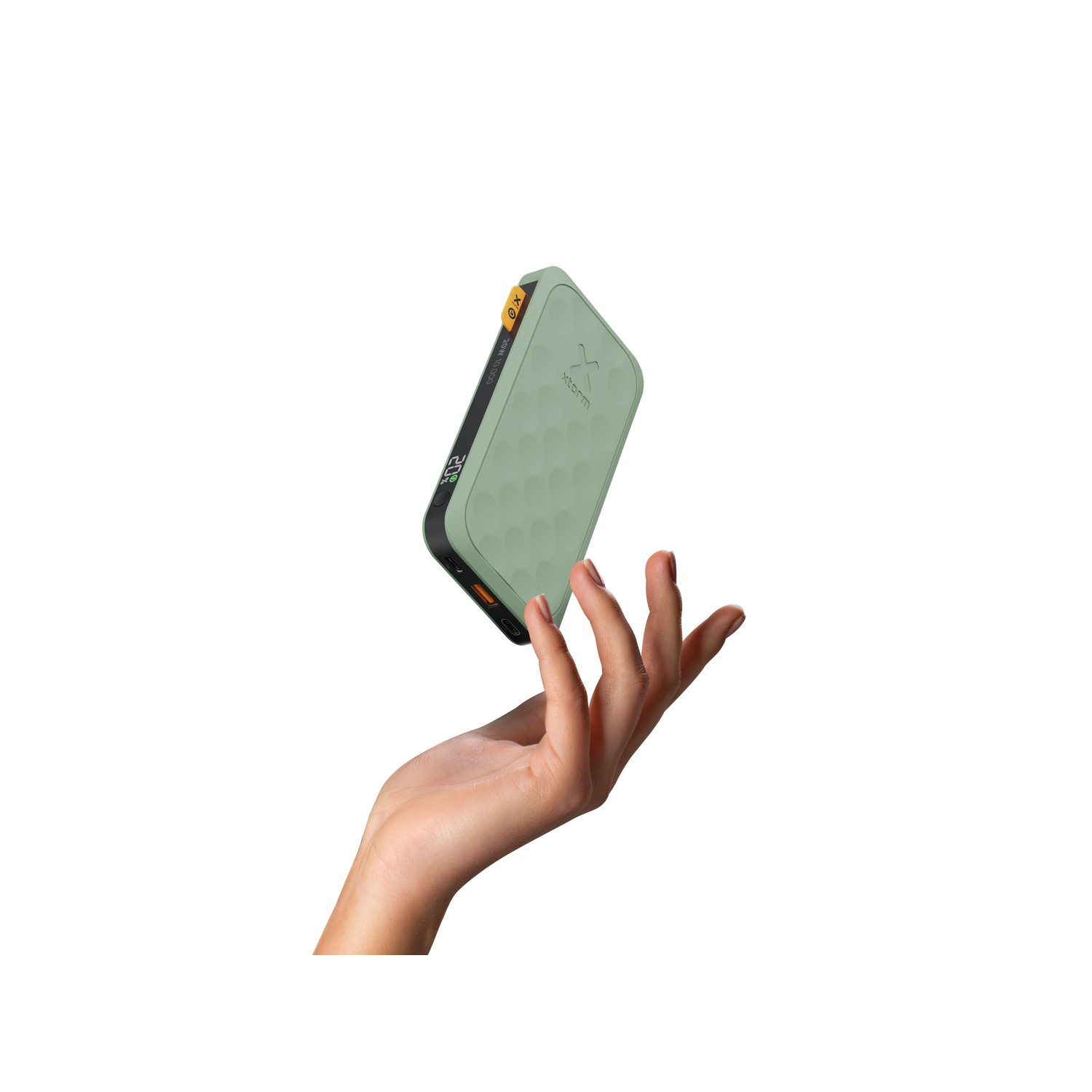 Hand holding a green and black power bank on white background.