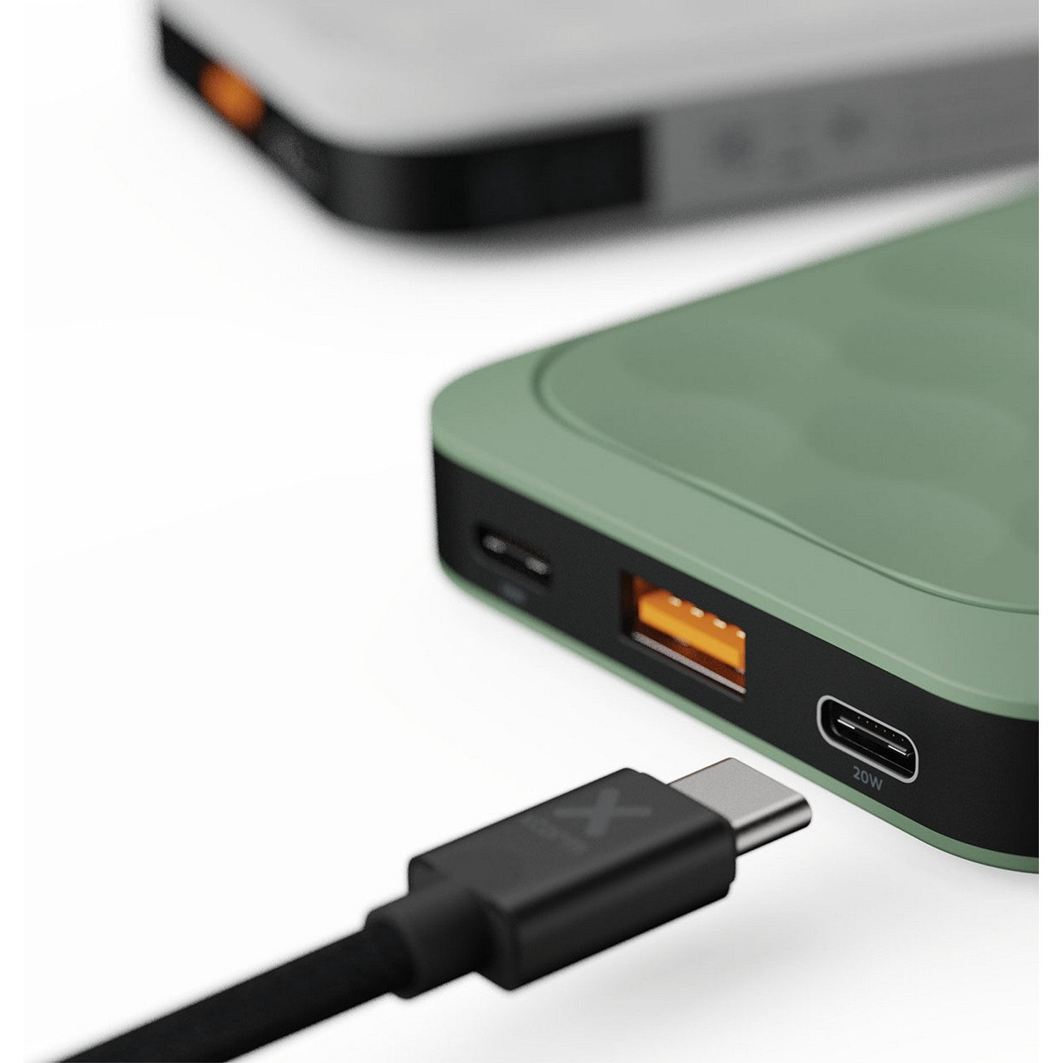 A black charging cable plugged into a green and black power bank.