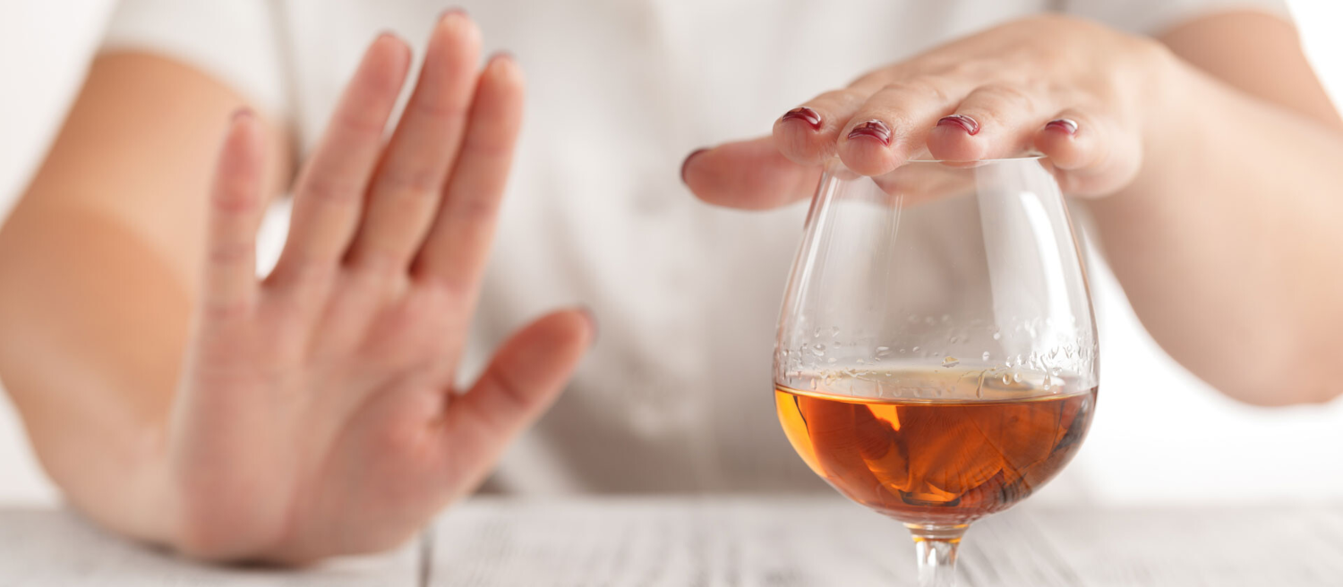 Személy visszautasít egy pohár alkoholt.