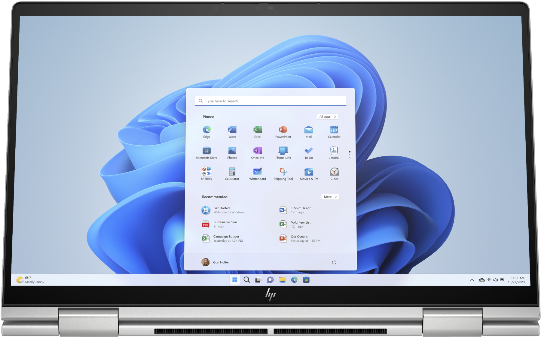 Un portátil con la interfaz de Windows 11 abierta. La pantalla muestra iconos de aplicaciones, con fondo azul y blanco.