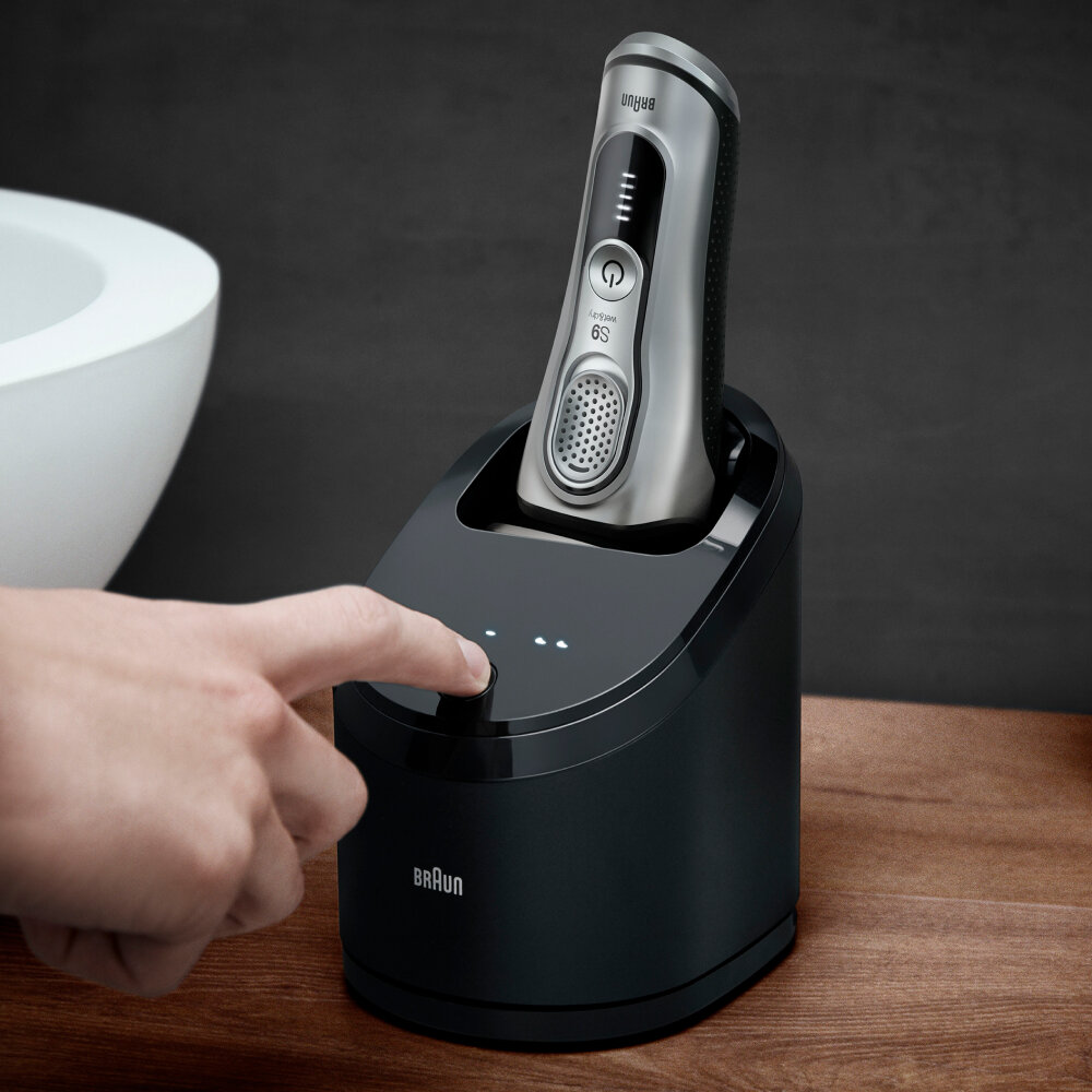 Ręka mężczyzny naciskająca przycisk na stacji ładującej.