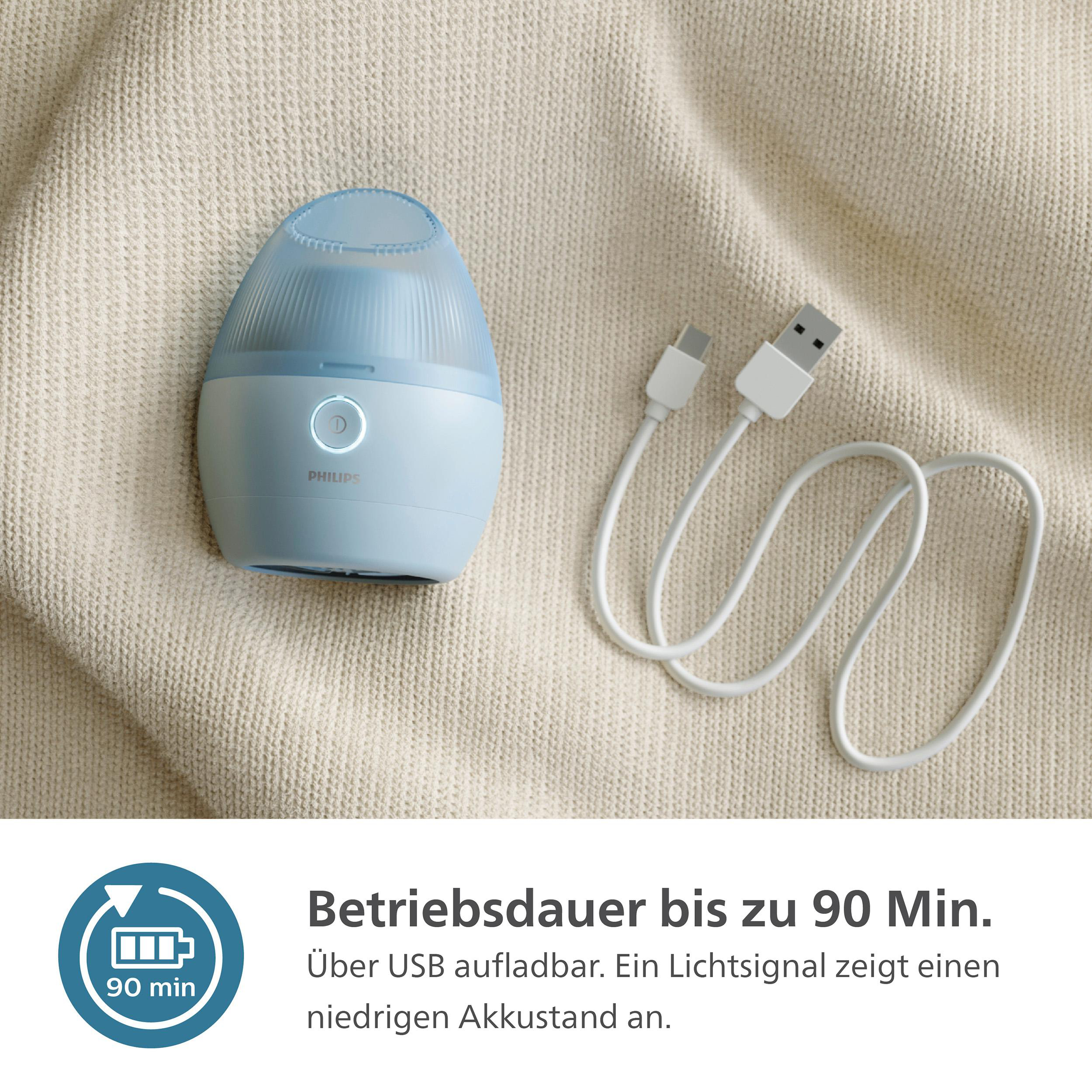 Ein blau-weißer Gesichtsreiniger auf beiger Oberfläche mit Ladekabel.