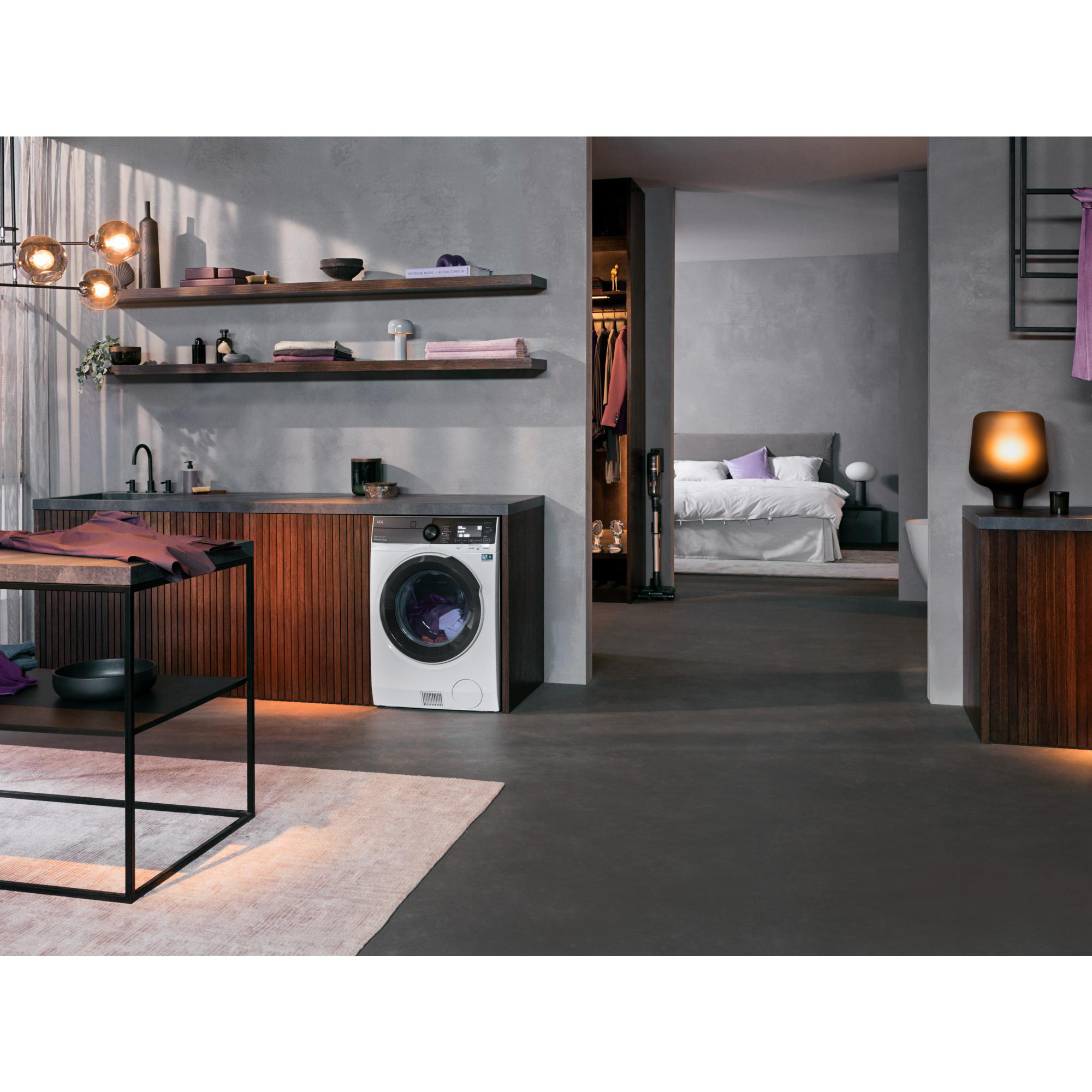 Waschküche mit Waschmaschine, Blick in ein Schlafzimmer. Dunkler Boden, Regale mit Dekoration.