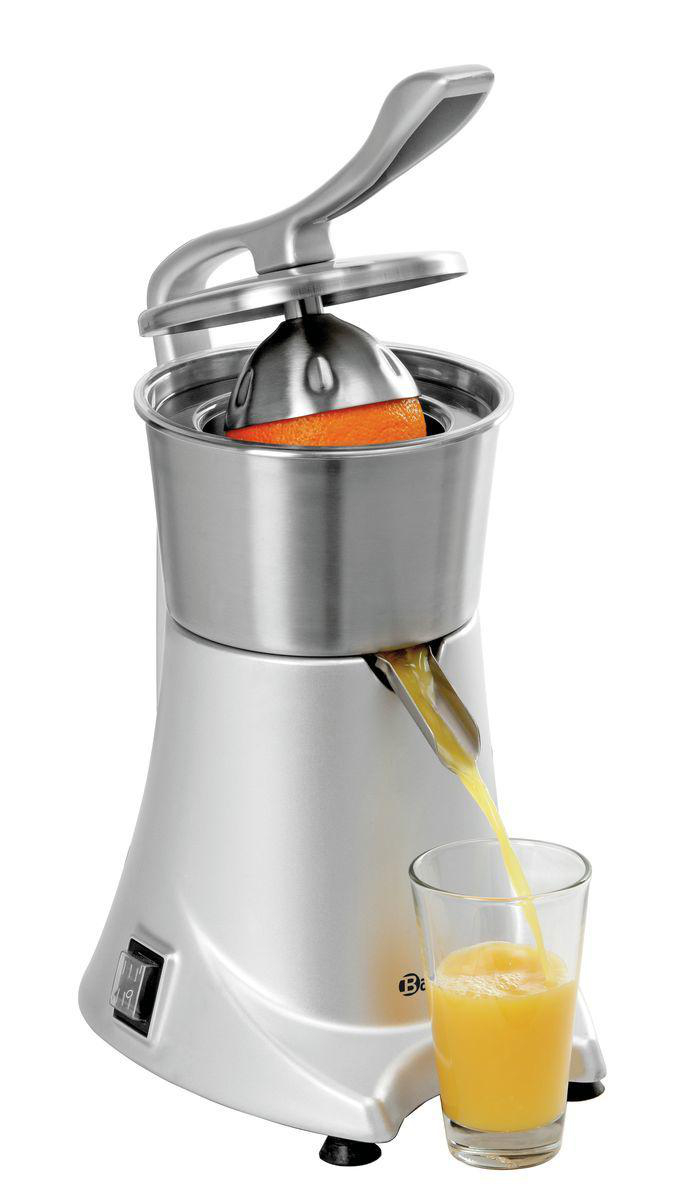 Ein silberner Entsafter mit einer Orange im Inneren presst Saft in ein Glas. Das Glas füllt sich mit gelbem Saft.