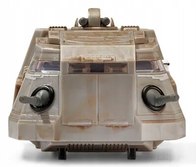 Mały, piaskowy pojazd z Gwiezdnych Wojen z dwiema lufami i oknami.