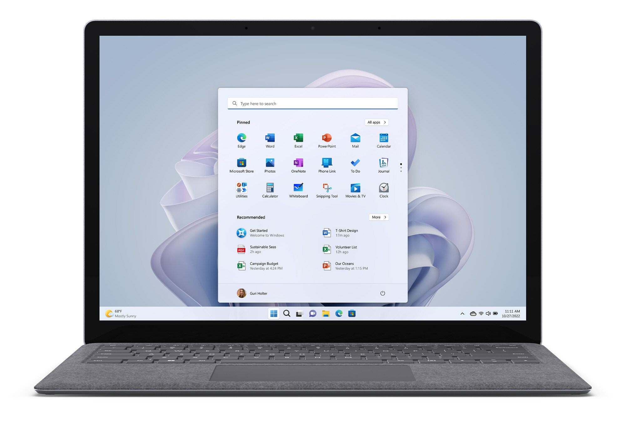 Laptop z otwartym ekranem startowym systemu Windows 11 i jasnoszarą klawiaturą. Ekran jest włączony.