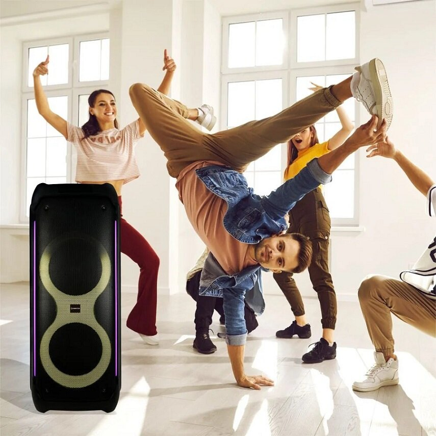 Grupa ludzi tańczących w pobliżu głośnika ze światłami.