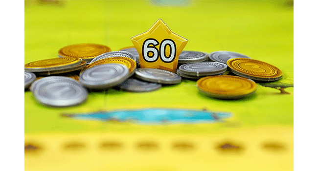 Társasjáték jelenet érmékkel és egy 60-as számú csillagdarabbal.