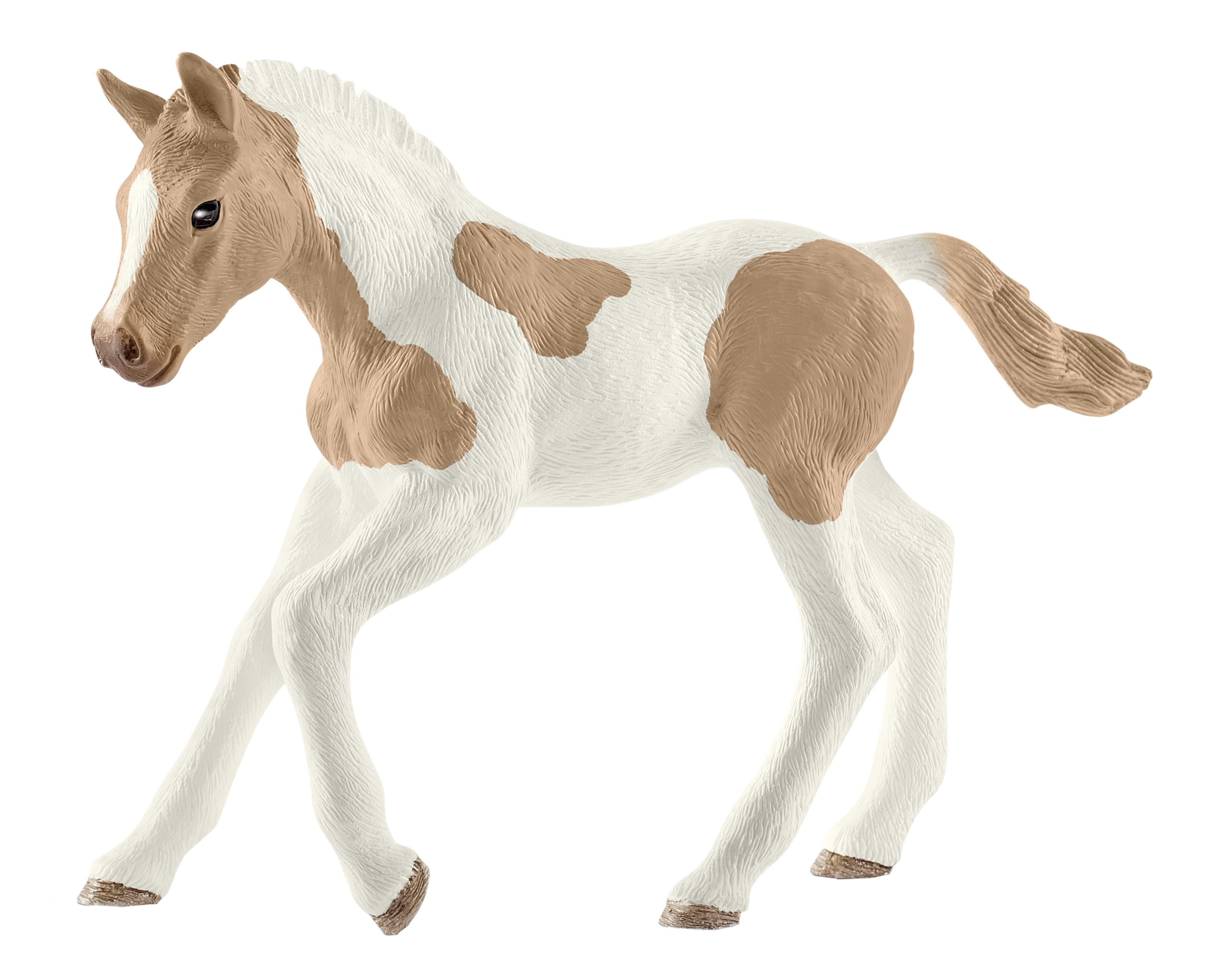 Poulain jouet, blanc avec des taches marron, sur une surface blanche.