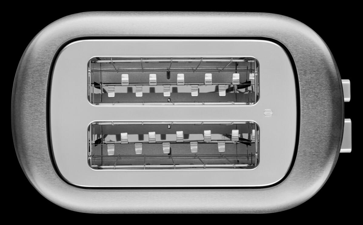 Draufsicht eines Toasters aus Edelstahl mit zwei Schlitzen auf schwarzem Hintergrund.