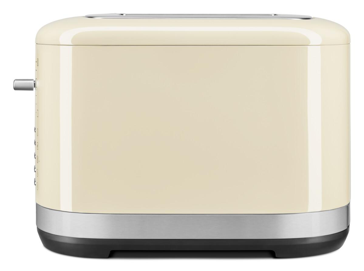 Ein cremefarbener Toaster mit silbernem Sockel und einem Hebel an der Seite. Seitenansicht auf weißem Hintergrund.