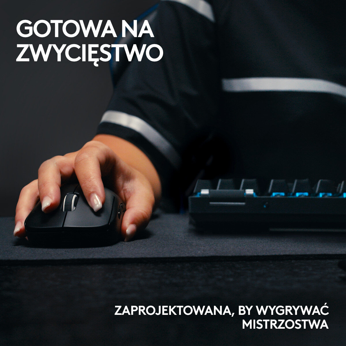 Dłoń trzymająca mysz do gier w pobliżu klawiatury, z tekstem powyżej i poniżej.