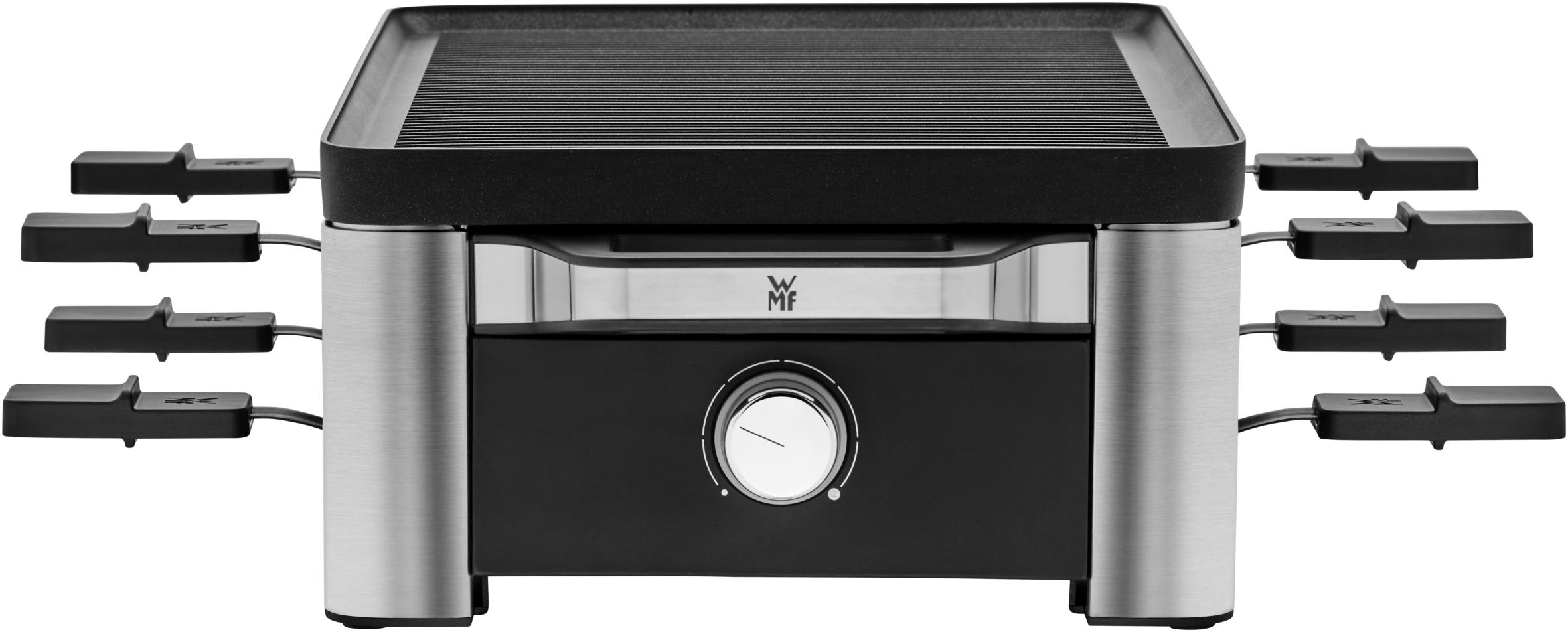 Raclette-Grill mit Käsehaltern und Heizelement. Umgeben von Werkzeugen.