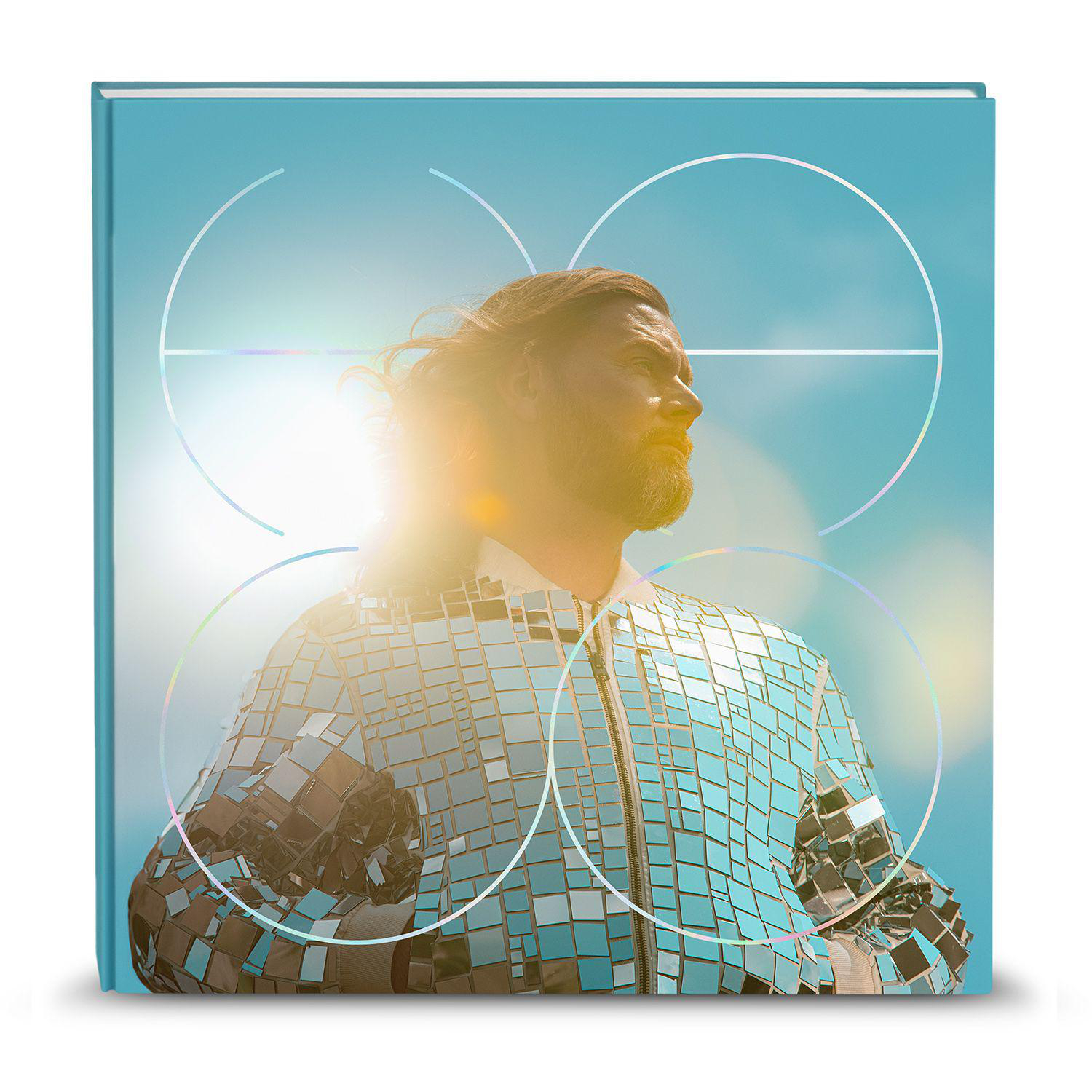Albumcover, Mann in verspiegelter Jacke, blauer Himmel und weiße Kreisgrafiken. Licht scheint auf den Mann.