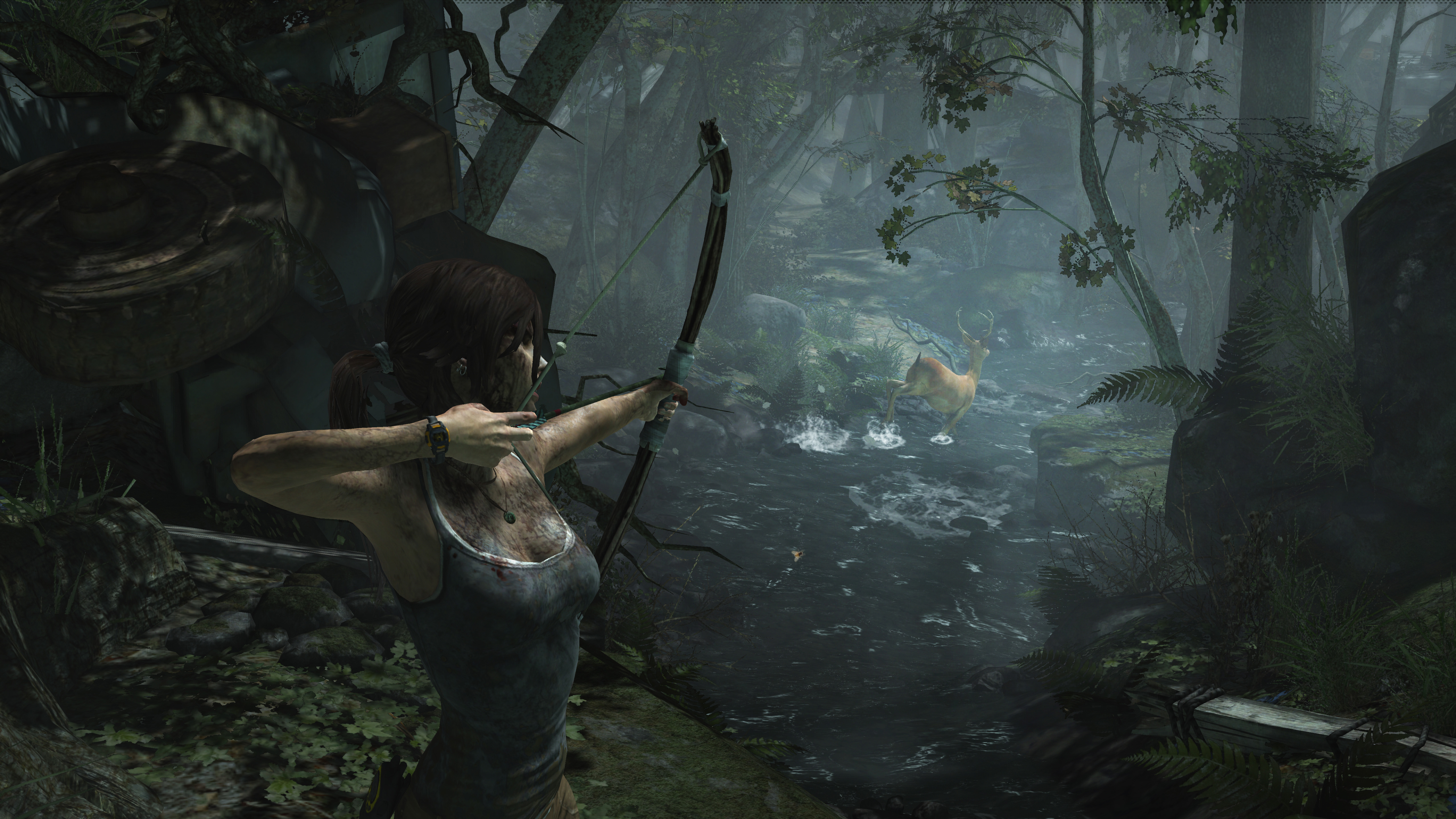 Lara Croft zielt mit einem Bogen auf ein Reh in einem Bach im Wald. Üppiges grünes Laub umgibt sie.