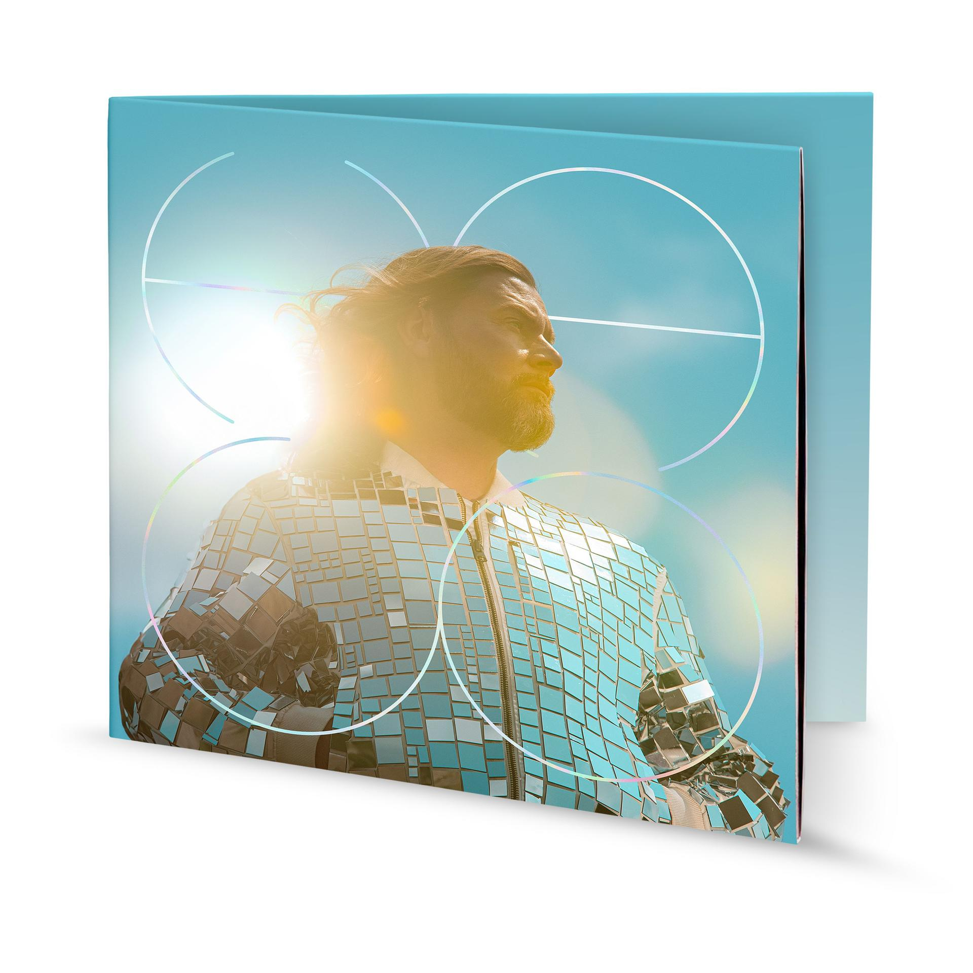 Ein Mann in einer glänzenden silbernen Jacke, mit blauem Himmel und Kreisen im Hintergrund.