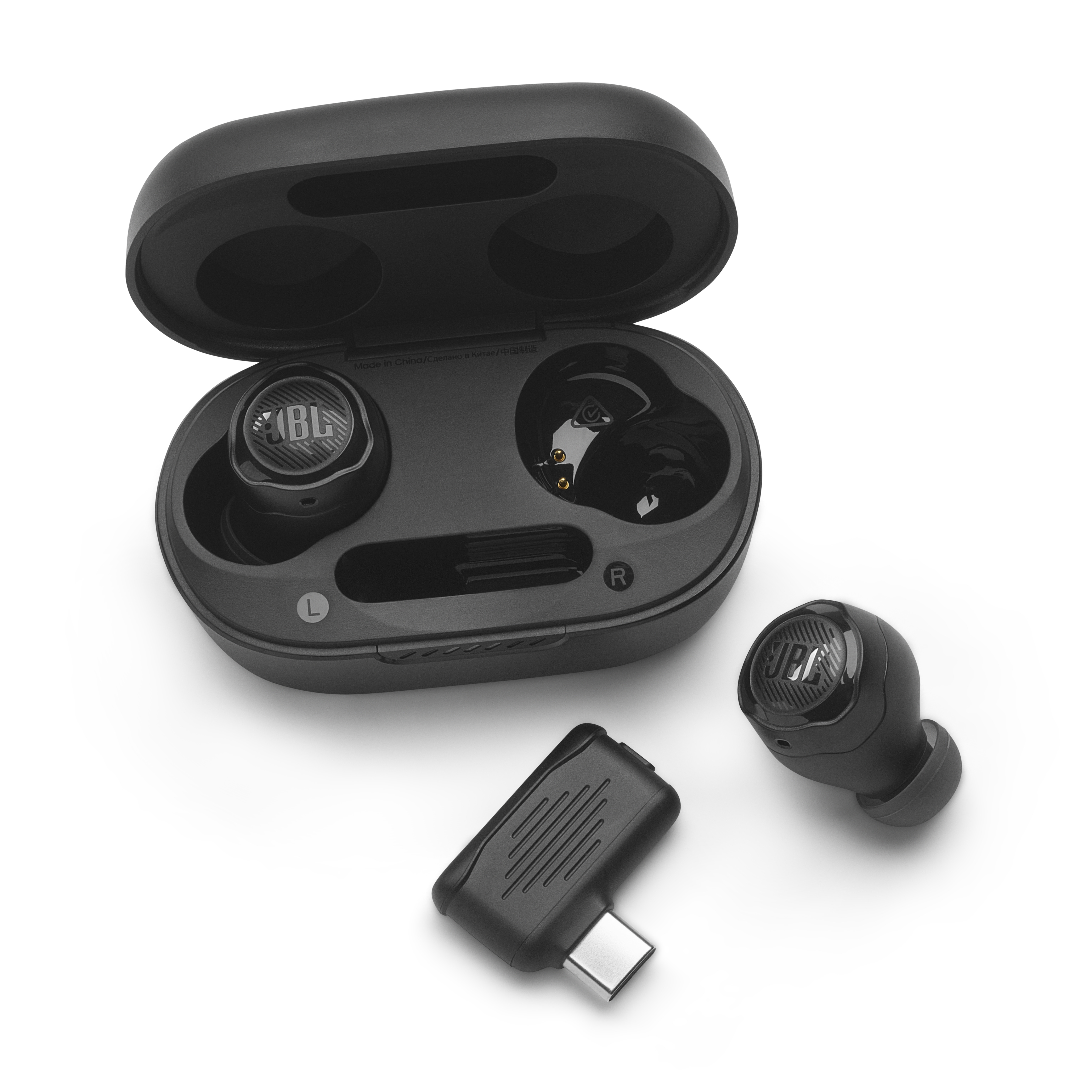 Siyah JBL kulaklıklar, şarj kutusu ve bir USB-C adaptörü, hepsi beyaz bir yüzeyde.
